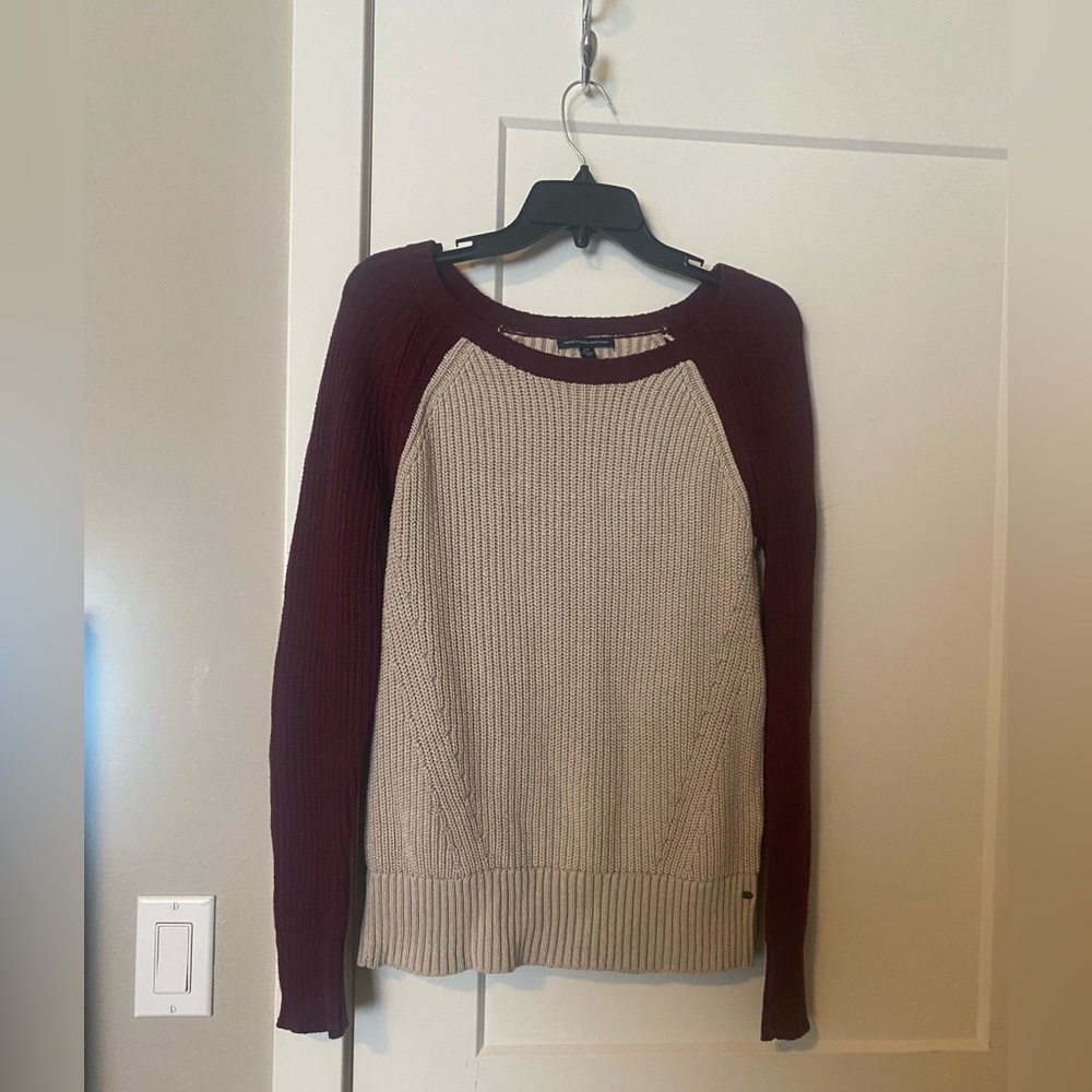 White sweater with red sleeves from American Eagle.